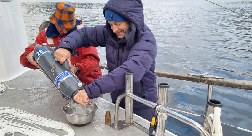 Photo of Prof James Bell and Paul Mitchell collecting eDNA samples from depths of more than 100m in Fiordland. Supplied by Fiordland Charters.